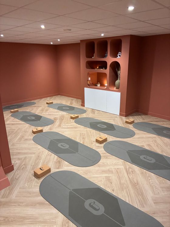 La salle de pratique, murs terracotta et tapis disposés au sol avec des briques.